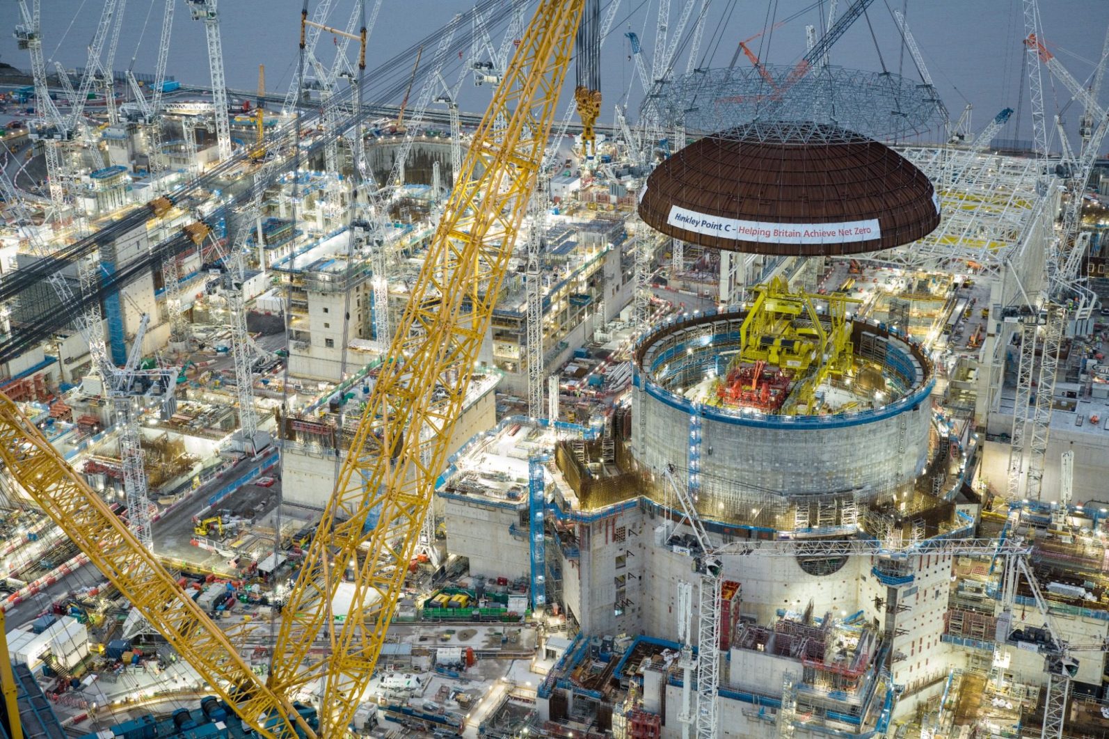 EDF - Hinkley Point C Construction site with cranes, machinery, and a large circular structure under assembly.